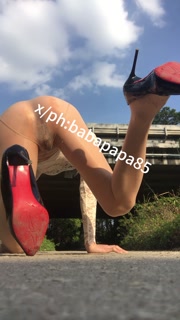 sissy in red bottom high heels and white hollow top exposes herself and pees under highway bridge