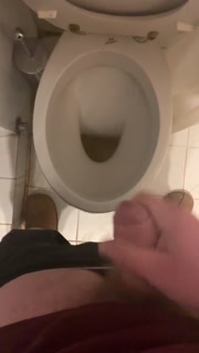 a guy pisses and then masturbates in the bathroom, cumming with his nice cock all over the place